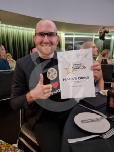 Man holding an award In a suit