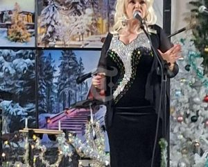 Country music Dolly Parton impersonator on stage singing.
