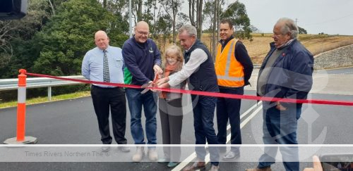 Mayor cutting ribbon on a new road.