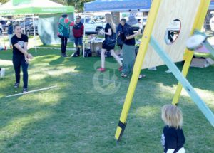 A group of people playing a game by throwing a bag through a target for NAIDOC week celebrations in Grafton.