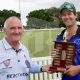 Cricket umpire shaking hands with a winner.