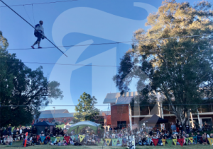 Person walking on a high wire in a town for NAIDOC celebrations.