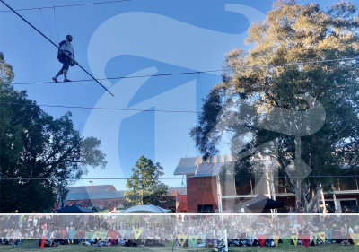 Person walking on a high wire in a town for NAIDOC celebrations.