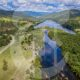 A Birds Eye view of a river with running water and hills beside it.