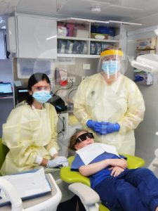 Dentist working on a persons teeth.
