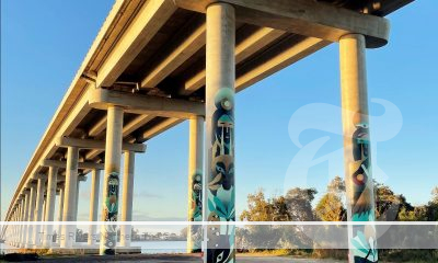 Under a bridge with art work on the pillars.