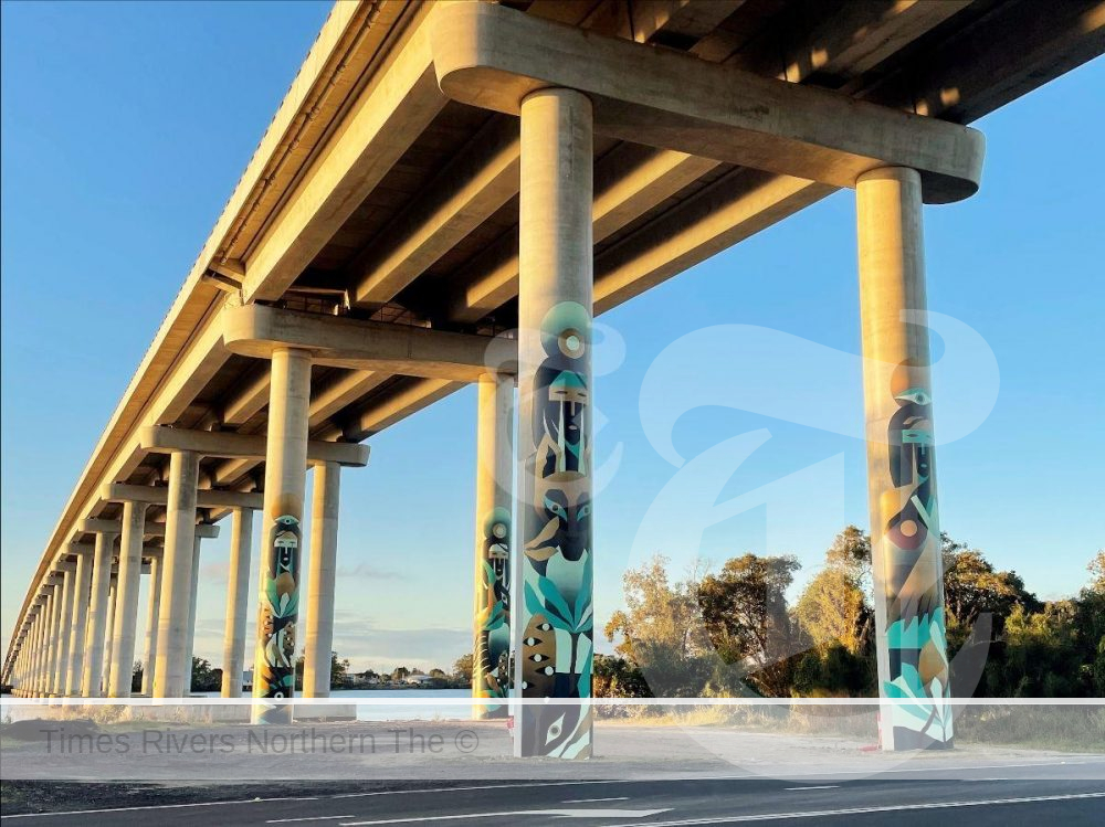 Under a bridge with art work on the pillars.