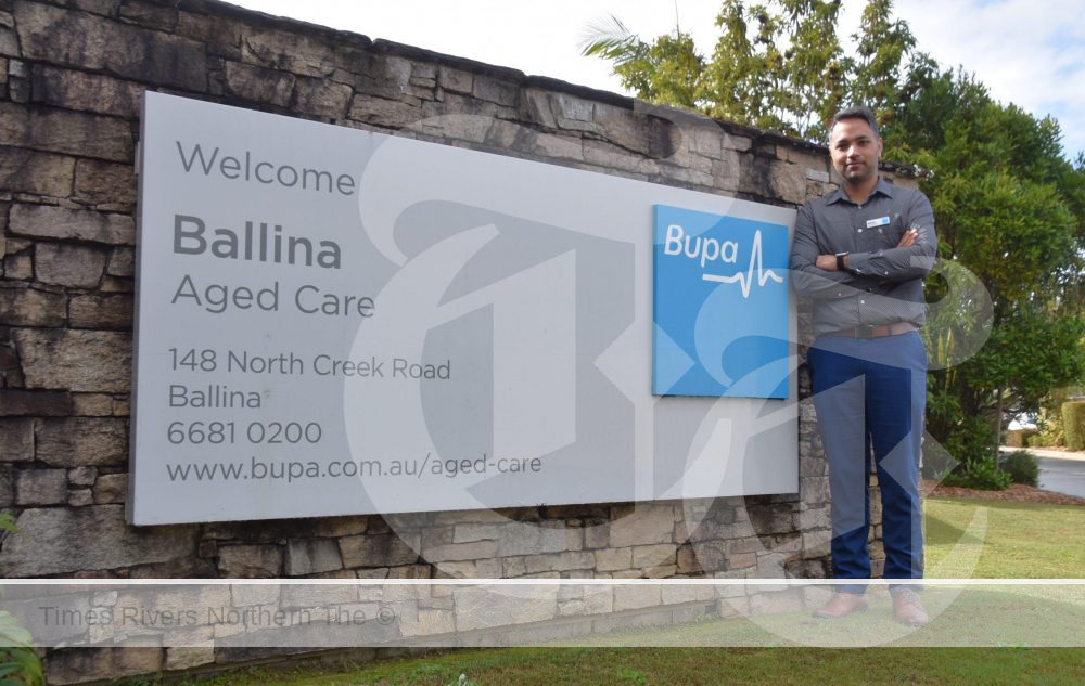Mickey Sahni GM Bupa Ballina standing in front of the Bupa Ballina sign.