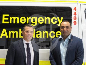 Member for Coffs Harbour Gurmesh Singh standing in front of an ambulance.