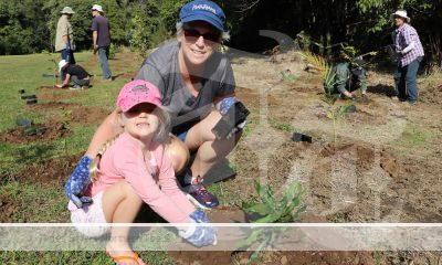 A girl and older women planting trees.