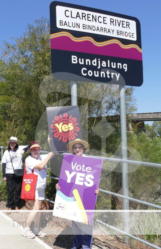 Walk for Yes participants stop for a picture with the bridge sign. The words Balun and Bindarray are from Gumbaynggirr and Bundjalung language and mean river in the languages of the people on either side of the river.
