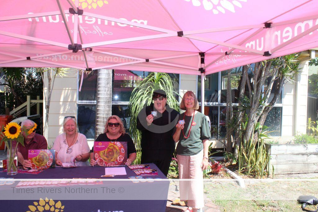 Momentum Collective at a market stall under a gazebo selling there book in honour of mental health awareness month.