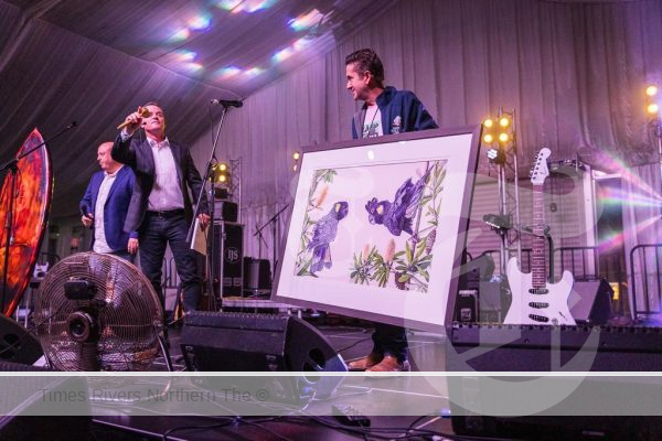 Founder of Byron Bay Wildlife Hospital Dr Stephen Van Mil holds up a print for auction at the Wild Aid benefit concert. Image: Lisa G Photography.