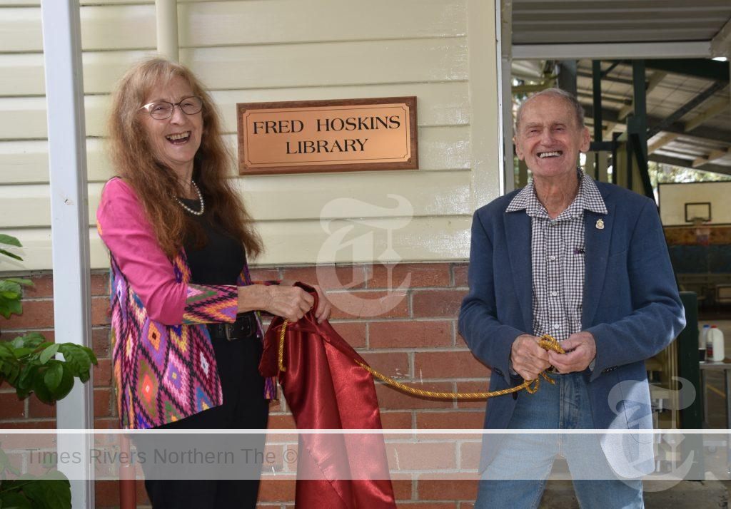 Janelle and Fred unveil the new sign to the library.